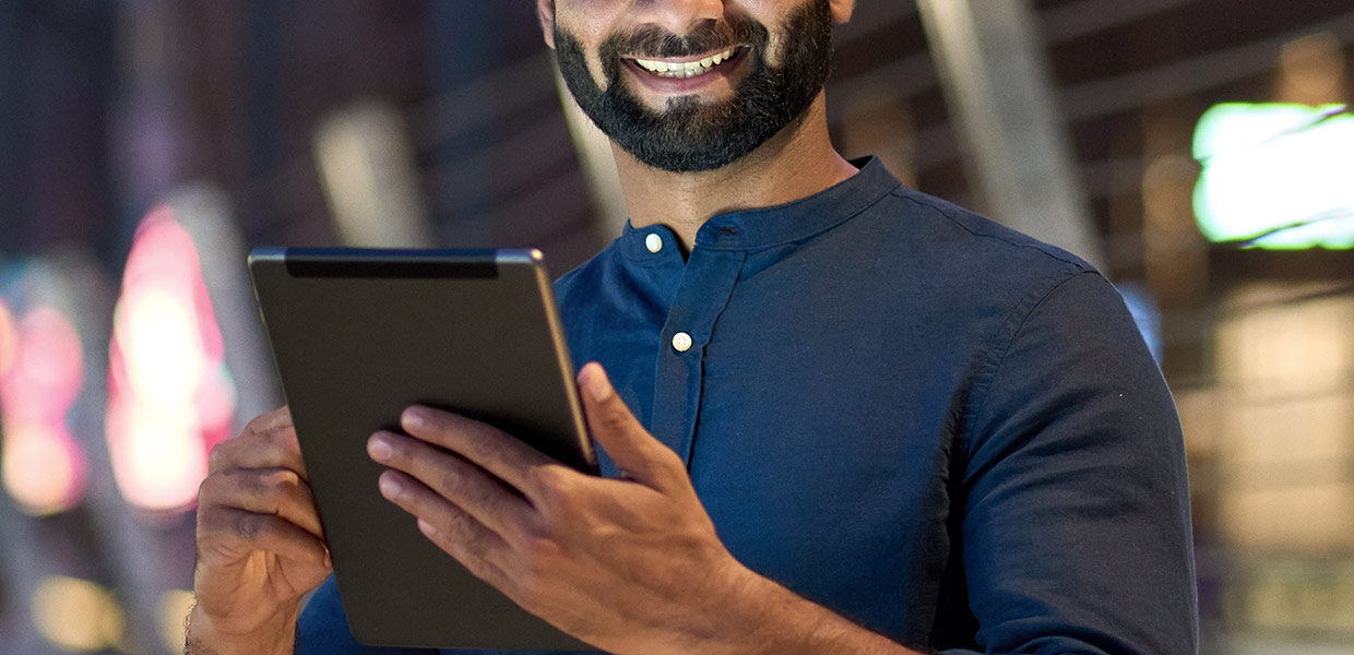 Smiling man holding a tabet device