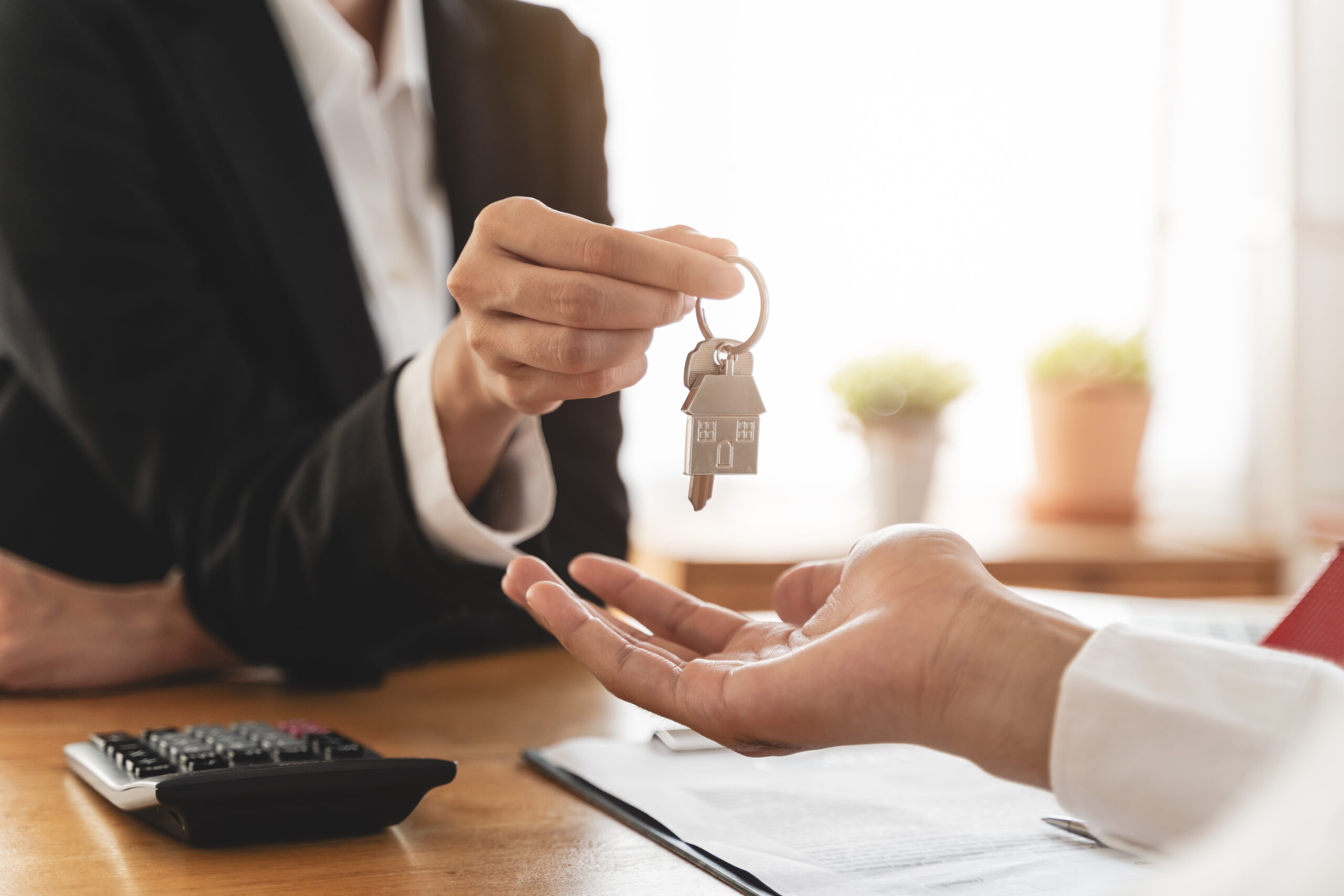 An estate agent handing a set of house keys to a new homeowner.